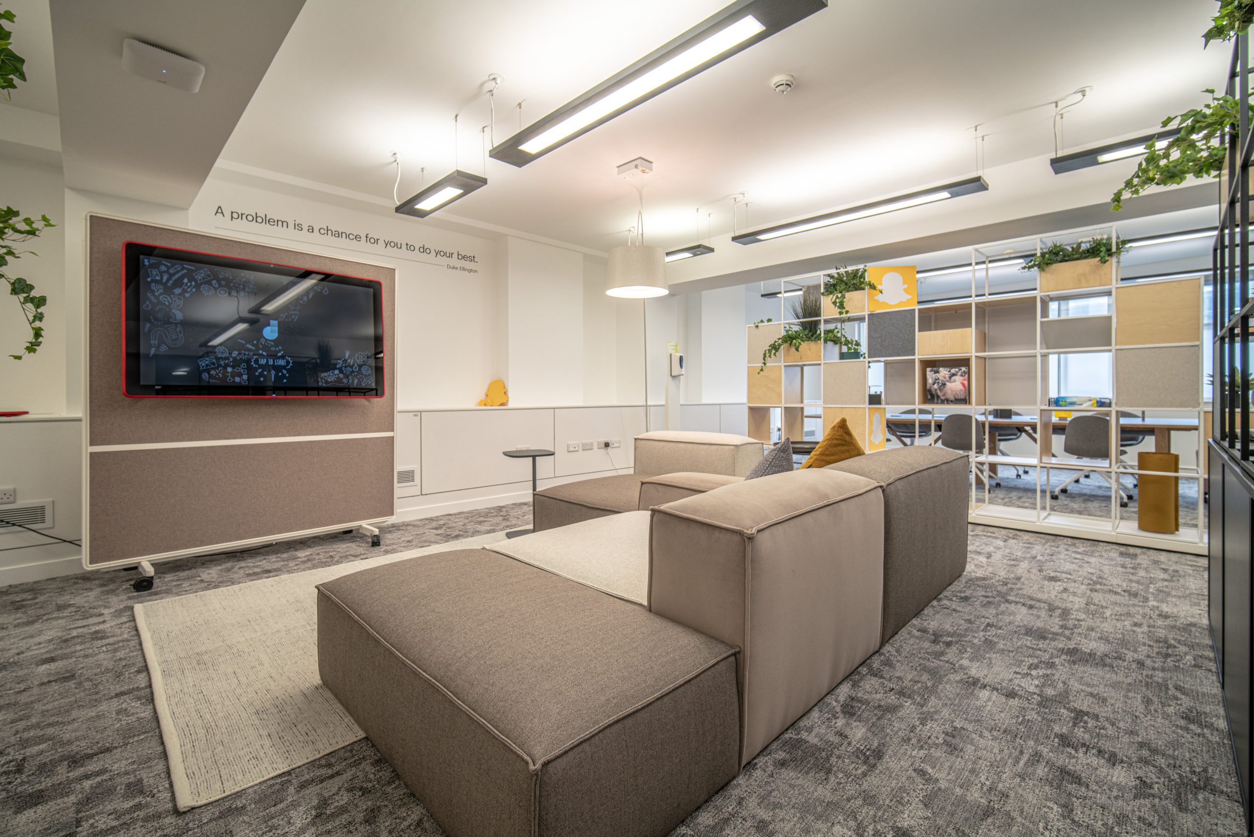 Open coworking space with communal tables and plants
